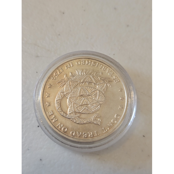 Silver coin with coiled snake design