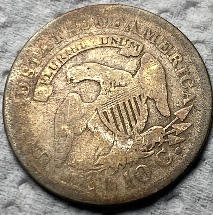 Old U.S. coin with eagle and stars design.