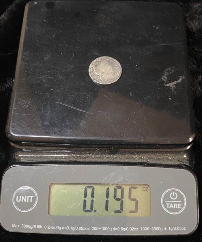 Coin on scale displaying weight in ounces.