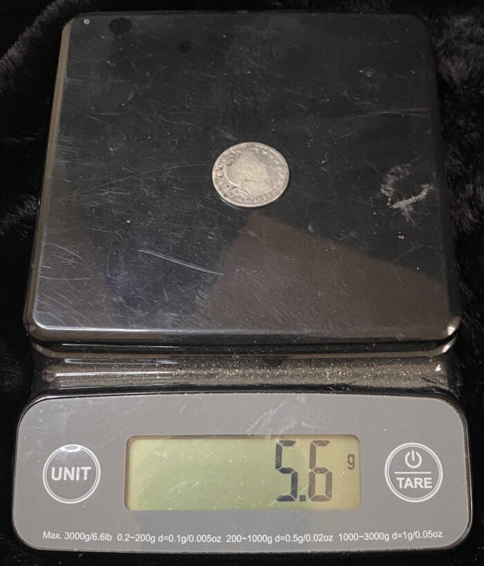 Coin weighing 5.6 grams on digital scale.