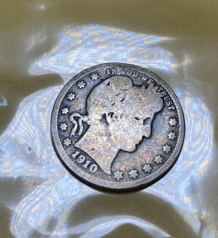 1910 Barber dime on reflective surface