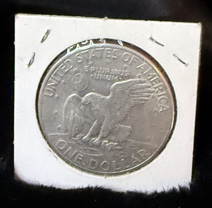 Eisenhower dollar coin with eagle and moon design.