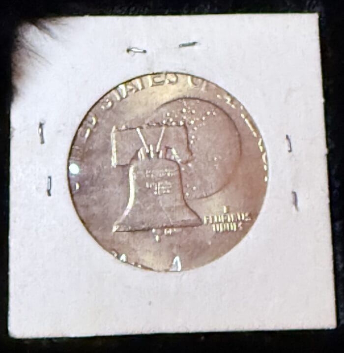 Coin with Liberty Bell design in holder.