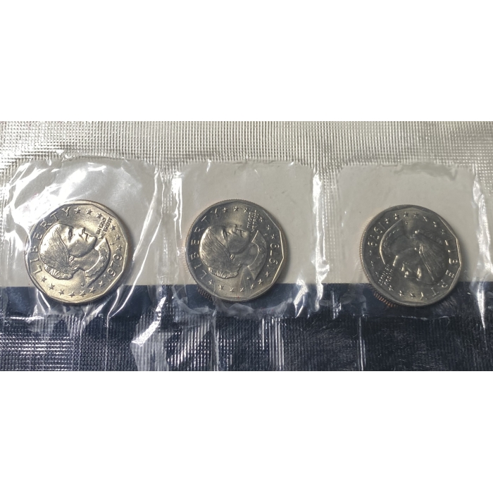 Three Susan B. Anthony dollar coins in plastic sleeves.