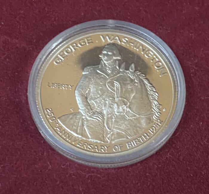 Commemorative George Washington coin on burgundy background.