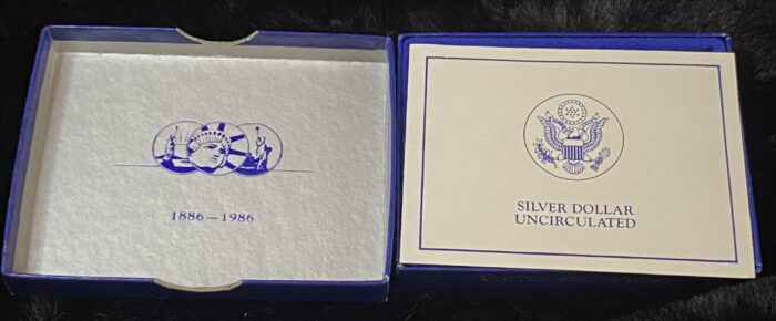 1986 Silver Dollar commemorative box with Liberty design.