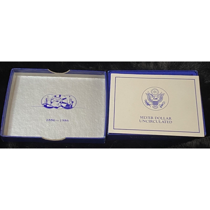 1986 Silver Dollar commemorative box with Liberty design.