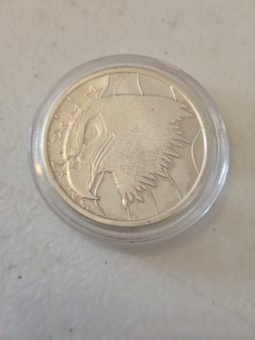 Silver coin with eagle design in case.