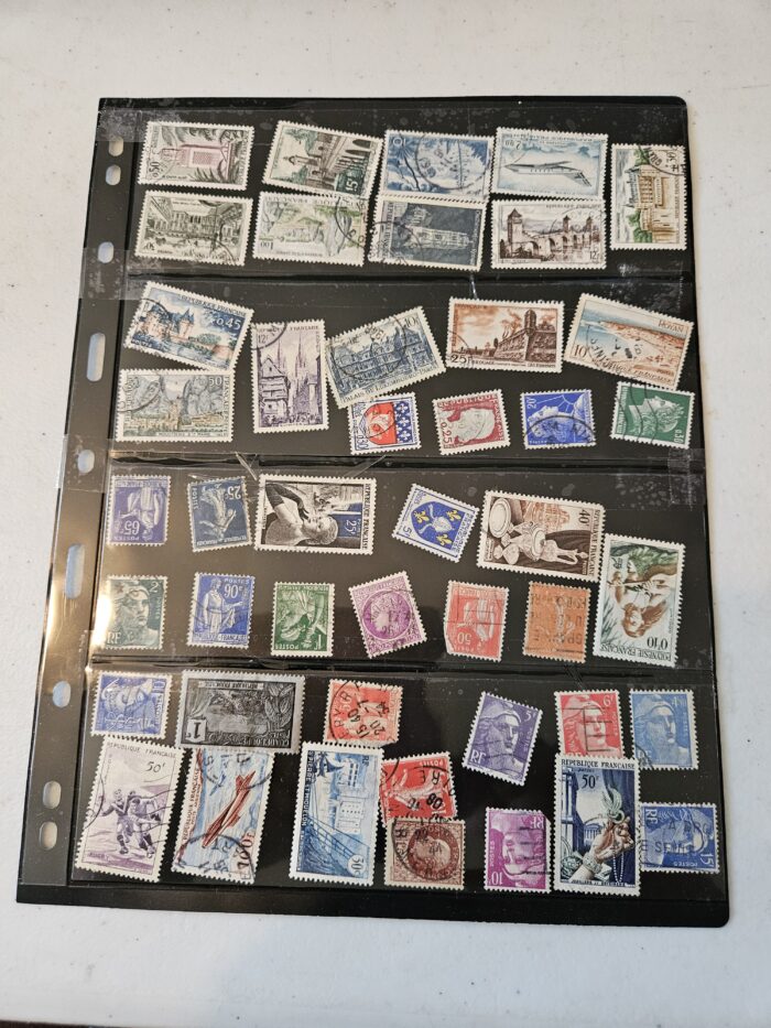 Collection of vintage stamps on black album page.