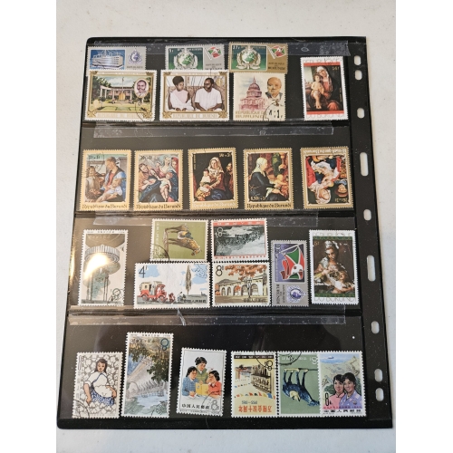 Collection of international postage stamps in album sleeve.