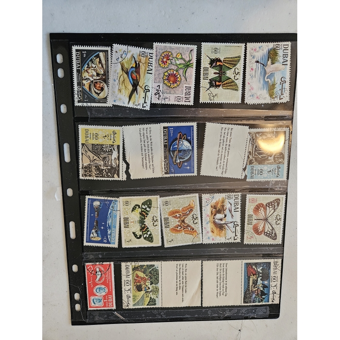 Collection of vintage Dubai postage stamps in album.