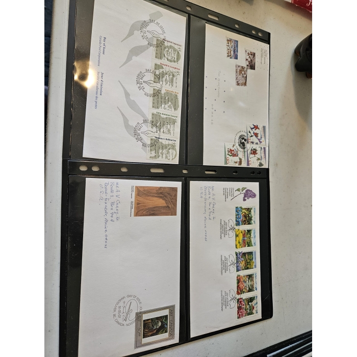 Four stamp-covered envelopes in a protective binder.