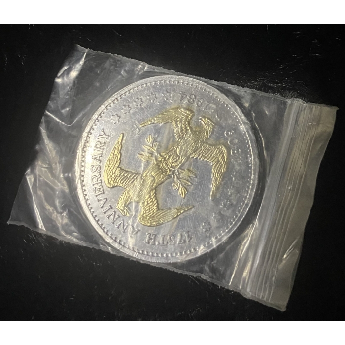 Commemorative coin in plastic case, eagle design.