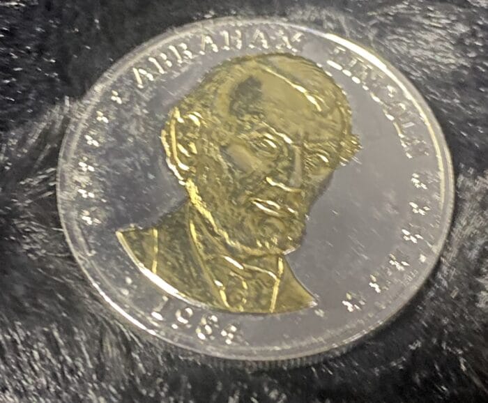 1984 Abraham Lincoln commemorative coin on black background.