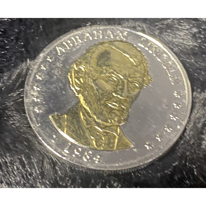 1984 Abraham Lincoln commemorative coin on black background.
