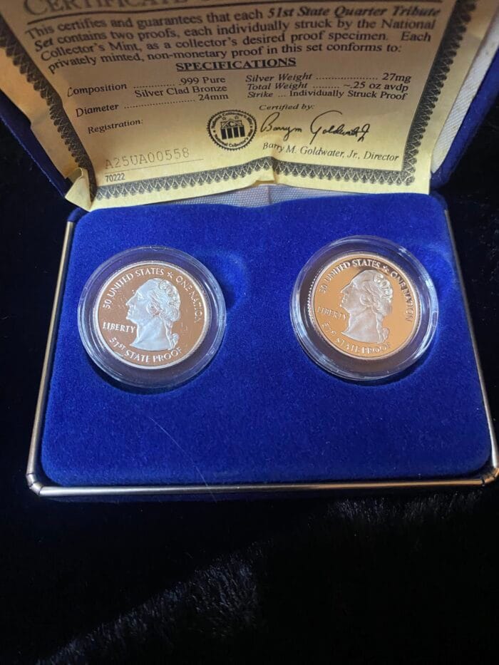 Certificate and two commemorative coins in a box.