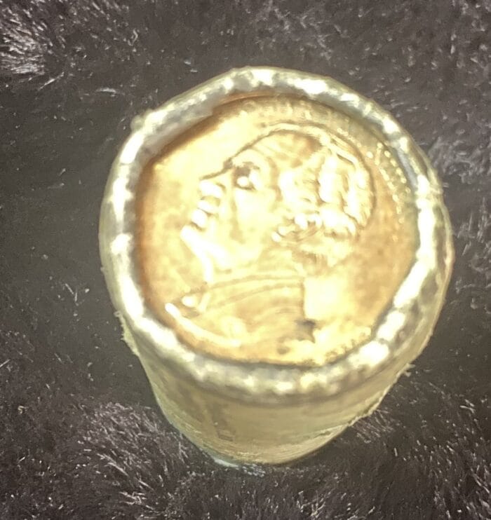 Close-up of a gold coin on black background.