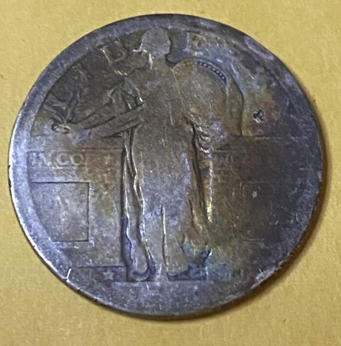 Old coin with intricate design on yellow background.